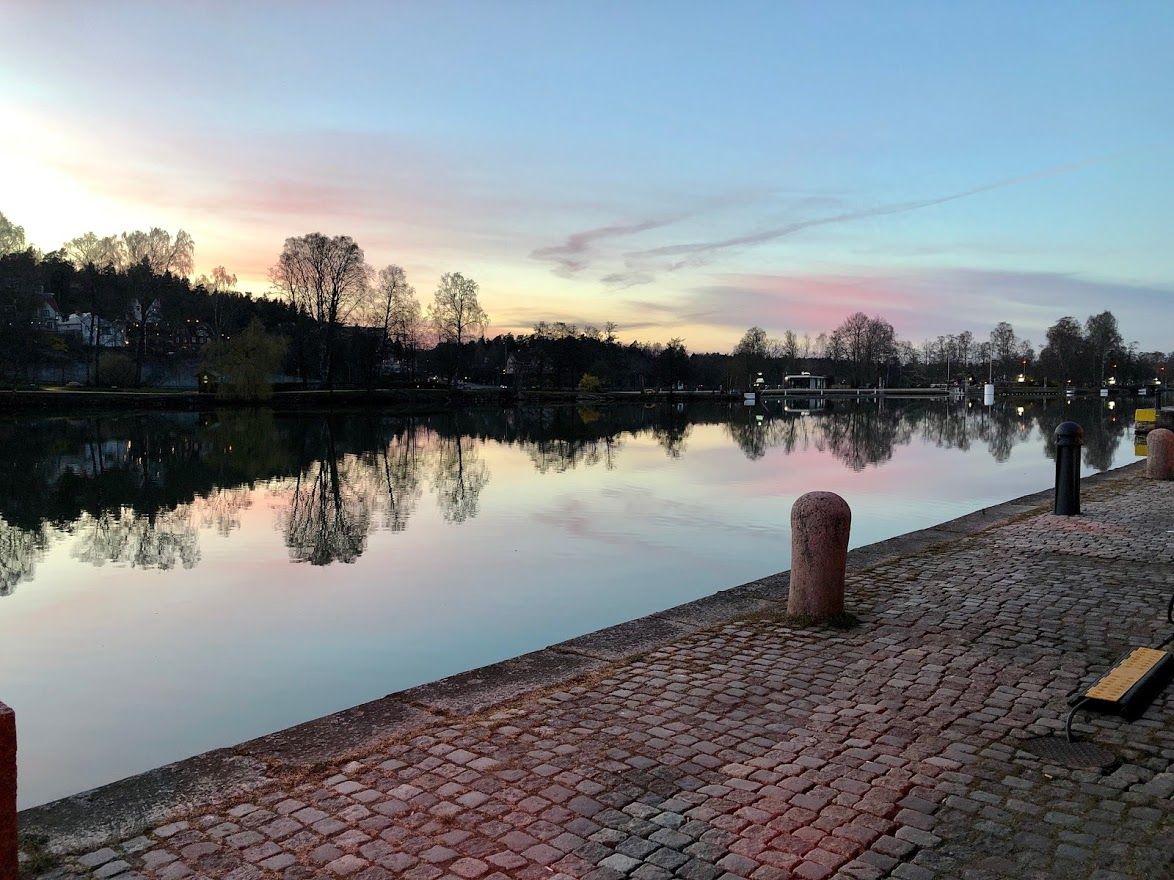 Kajstråk med kullersten vid kanalen i solnedgång